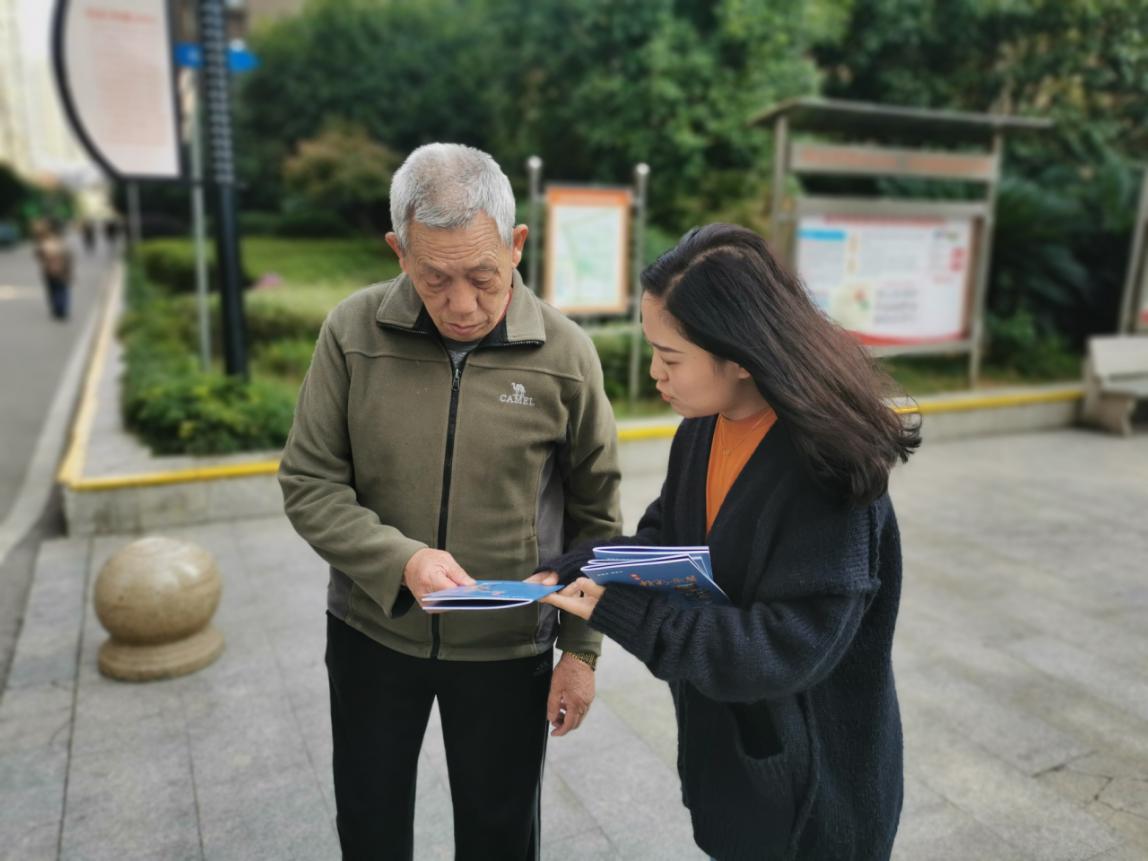 钰龙社区工作人员在向居民推荐《岳麓读本》.jpg 钰龙社区工作人员在向居民推荐《岳麓读本》.jpg