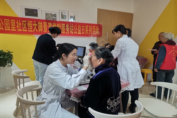 义诊区医务志愿者在为老人检查眼睛.jpg