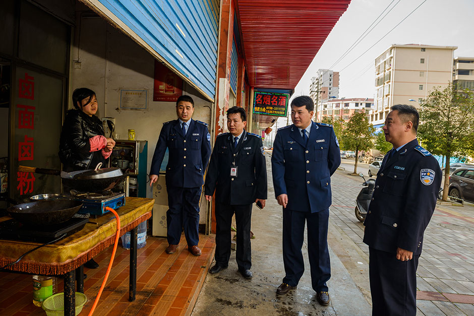 在一家餐馆门口，城管局党组成员、执法大队长卿青与副大队长晏建农正劝导老板清扫门面前的垃圾和污水。城管执法大队队员一边给店主讲道理，一边主动帮其打扫。 一位女城管队员告诉记者，他们出去执法时，经常都会遇到一些蛮不讲理的店主，做了大量工作，却又得不到市民的理解和支持，还不时遭到谩骂，这让他们很受伤、很委屈。