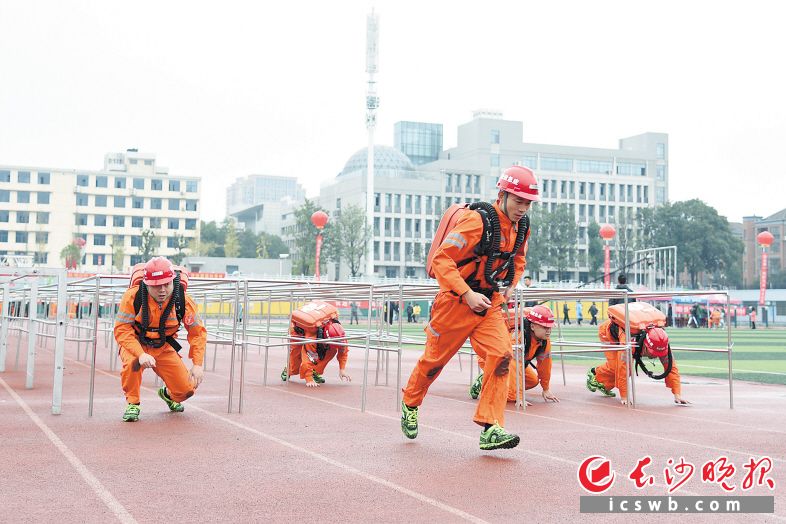 　　参赛队员负重奔跑，同时还要钻矮巷口。长沙晚报全媒体记者 刘琦 摄