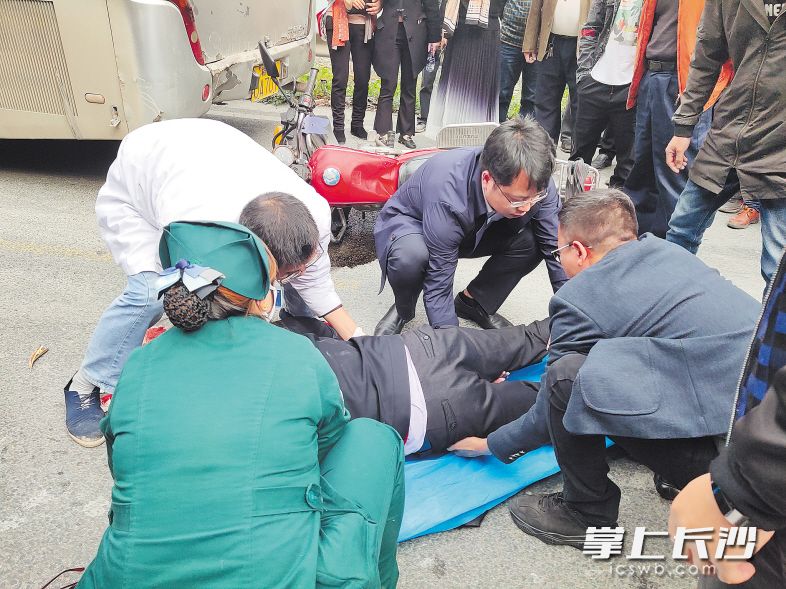 　　湘雅医院员工正在协助当地120救治受伤的摩托车司机。 医院供图