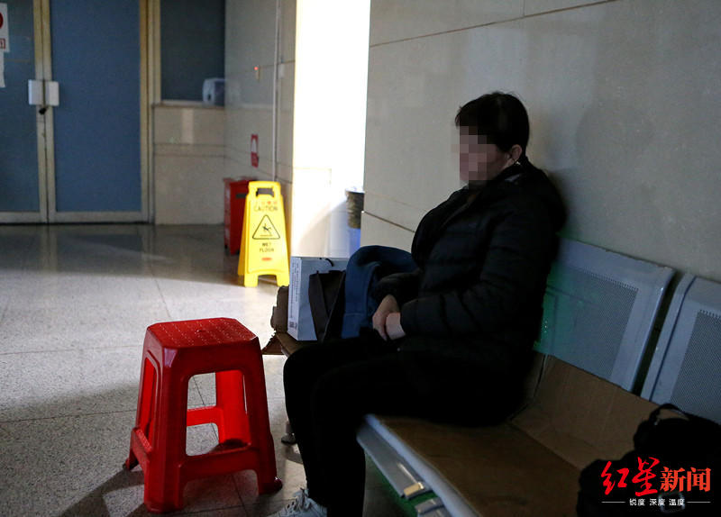 韩某的母亲庄女士坐在医院楼道休息凳上