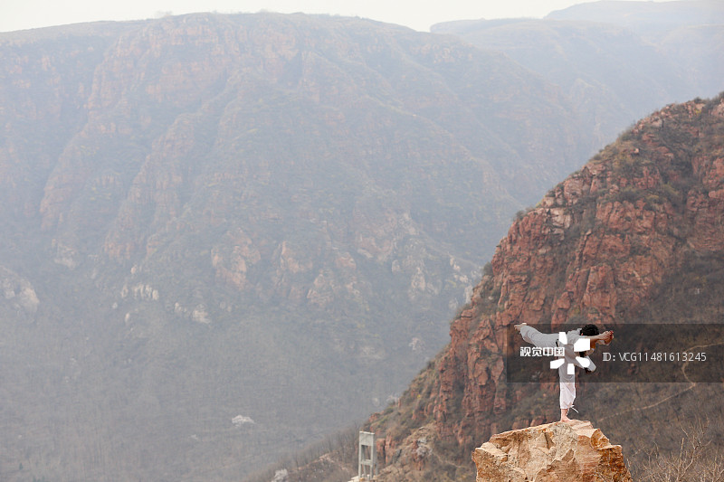 2016年03月23日，河南省郑州市，在新密一群山山顶，10多位中外瑜伽爱好者在海拔几百米的悬崖峭壁上演高空“极限瑜伽”，令在场的游客看的心惊肉跳。