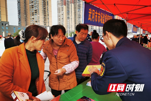 武冈市市场监督管理局工作人员向市民普及用药安全。