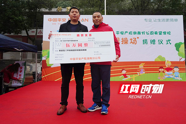 平安产险湖南分公司副总经理张贤波（右）为学校赠送捐款。
