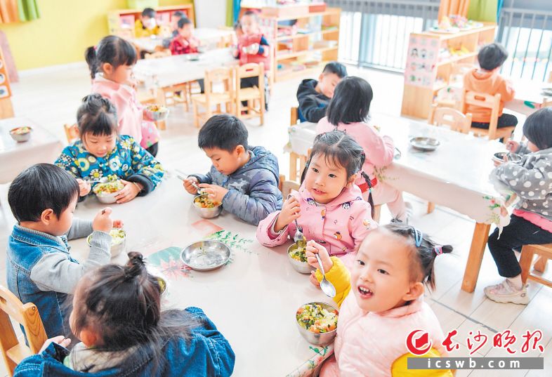 　　普惠幼儿园孩子们正在吃午餐，每天都有专业的营养师配餐，伙食费300元/月/人。
