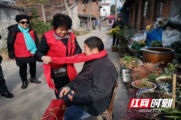 志愿者给社区困难居民系上红围巾，愿困难居民一家人在以后的日子越过越红火。.jpg