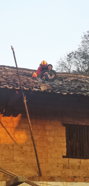 12月10日,娄底涟源市金石镇,消防员正在营救被困屋顶的失明老人