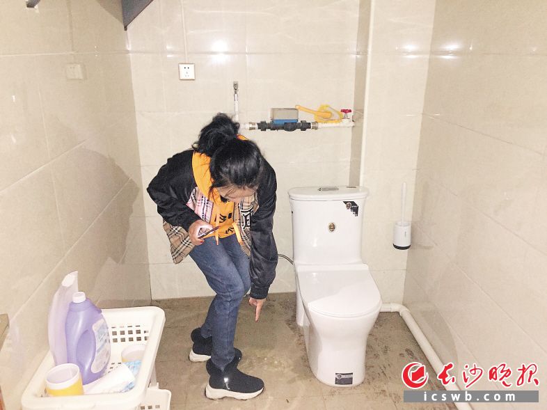 　　袁女士踩在洗手间的水里，一脸无奈。长沙晚报全媒体记者 朱炎皇 实习生 邹菁 摄影报道