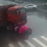 女子骑电动车被卷入货车底 惊吓到颤抖却毫发无损