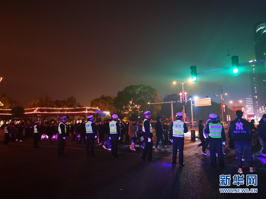 1月1日，长沙市公安局交警支队天心大队的交警在当晚人流量最大的湘江路西湖路口疏导保畅。新华社记者 张晓迎 摄