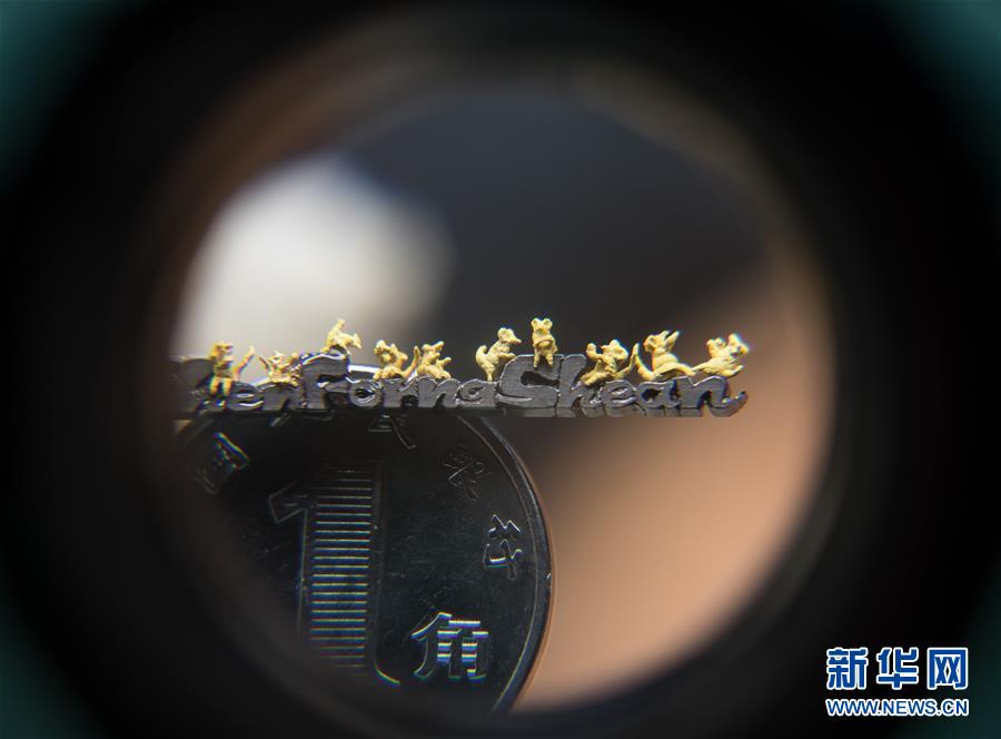 微雕作品《十全十美》是用黄金在铅笔芯上雕刻出10只表情各不相同、姿势优美的小老鼠（1月7日摄）。新华社记者 金立旺摄