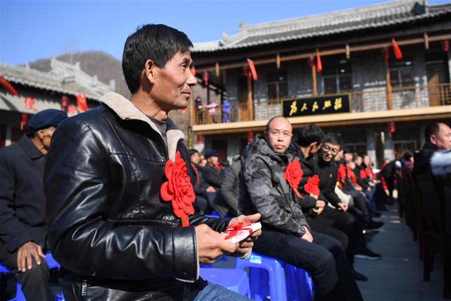 1月7日，村民康耀林（前）在分红大会上领到分红。 新华社记者 陈斌 摄