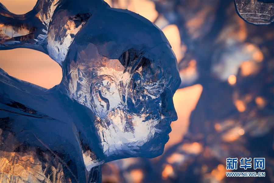 在哈尔滨冰雪大世界园区中，主题各异的冰雕作品引人入胜（1月9日摄）。 近日，第36届中国·哈尔滨国际冰雪节在哈尔滨冰雪大世界开幕，吸引国内外的游客前来观冰赏冰。在哈尔滨冰雪大世界园区中，晚霞给工艺精湛的冰雕作品“披”上鎏金“外套”，晶莹剔透的冰雕仿佛被落日点冰成“金”。 新华社记者 王松 摄