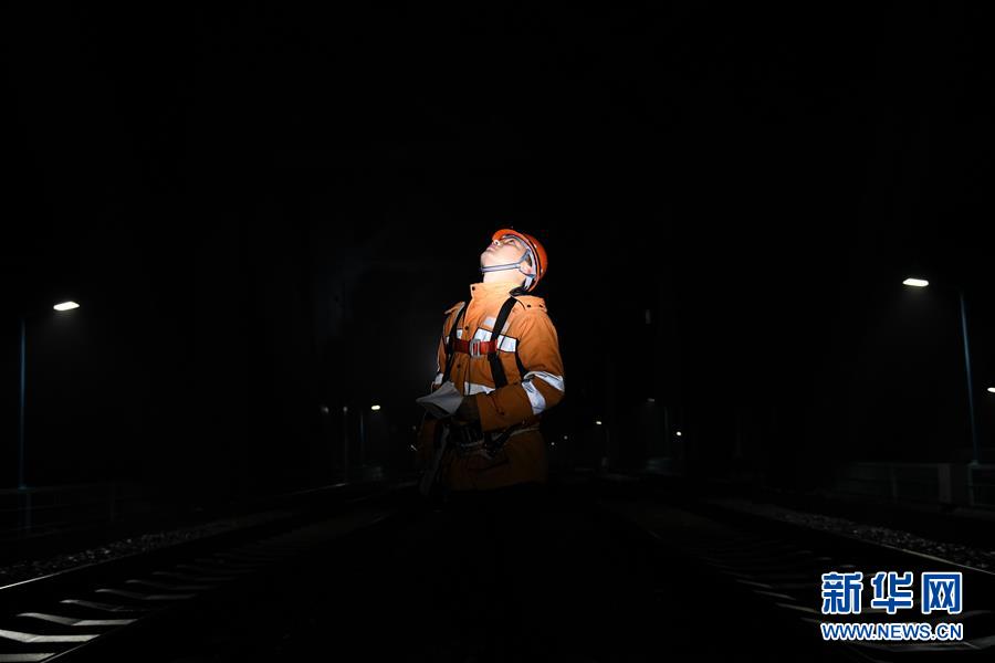 1月10日凌晨，桥隧工郭庆飞在检查大桥防落网。 新华社记者 张端 摄