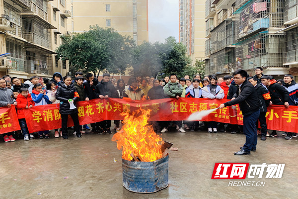 活动现场居民对准现场设置的燃火点进行实操灭火。.jpg