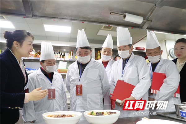 新长福工作人员向专业评审团介绍厨房情况及菜品。