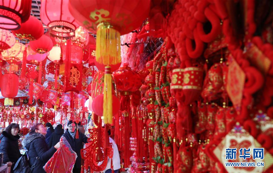 1月12日，市民在安徽省淮北市久兴年货市场上选购对联、灯笼、中国结等饰品。新华社发（李鑫 摄）
