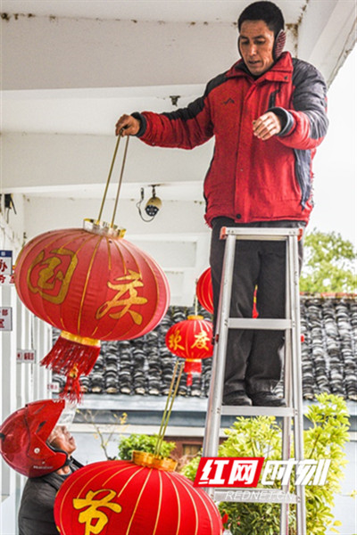工人在道县县委办公楼走廊更换新春灯笼。