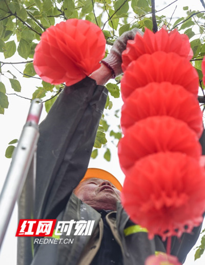 园林工人在县城主要街道悬挂各式灯笼。