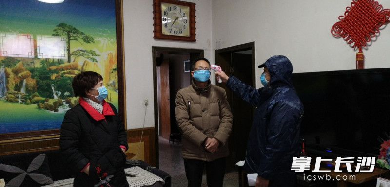 镇头镇甘棠村村医廖松林为武汉返浏人员测量体温。长沙晚报通讯员 吕小雨 摄