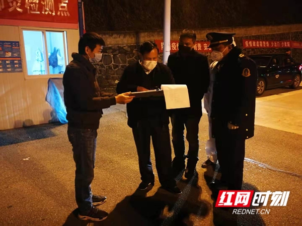 曾祥元在通道站点卡口检查防疫台账资料。