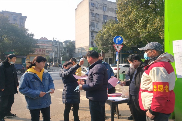 工作人员对出入市场的群众进行体温测量.jpg
