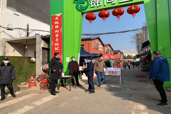 在市场大门前发放传单宣传疫情防控工作.jpg