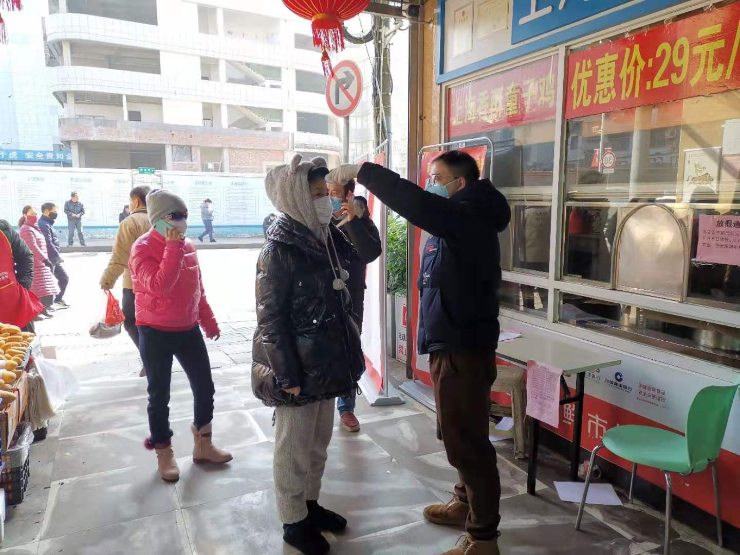 荷花池生鲜市场为市民测体温。