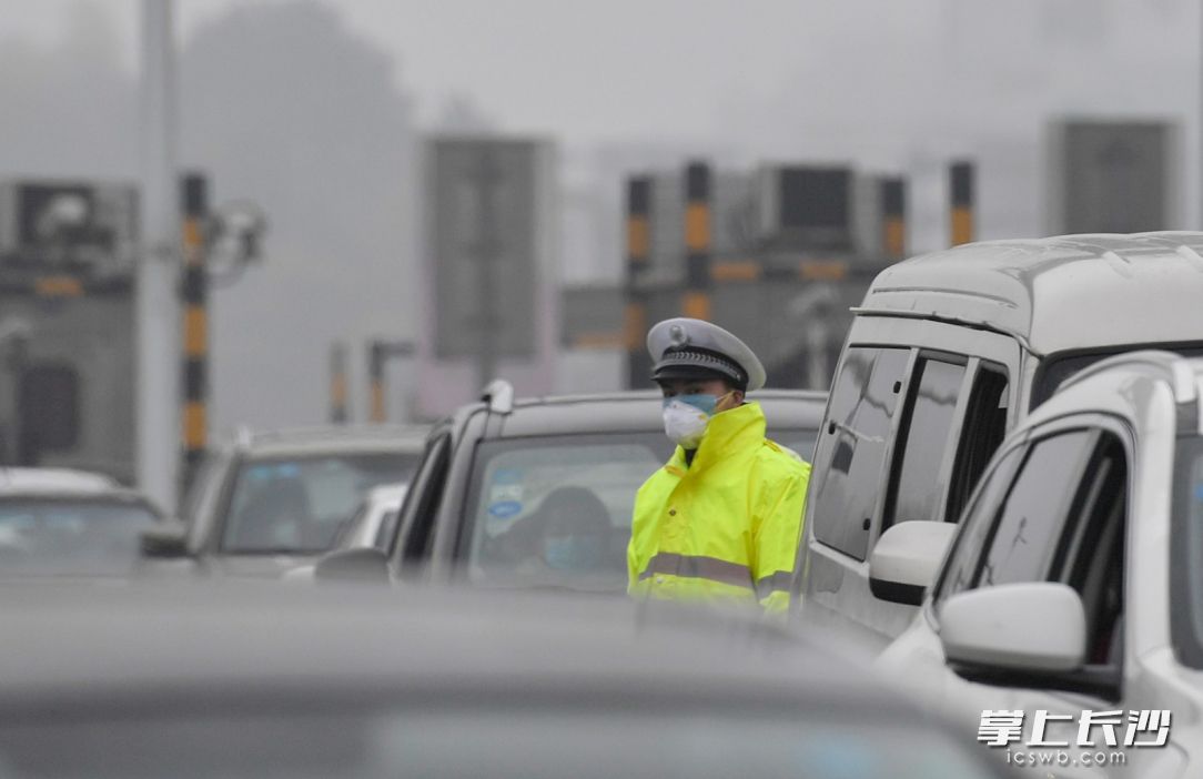 2月2日下午，长张高速上执勤的交警正在指挥交通。长沙晚报全媒体记者 邹麟 摄