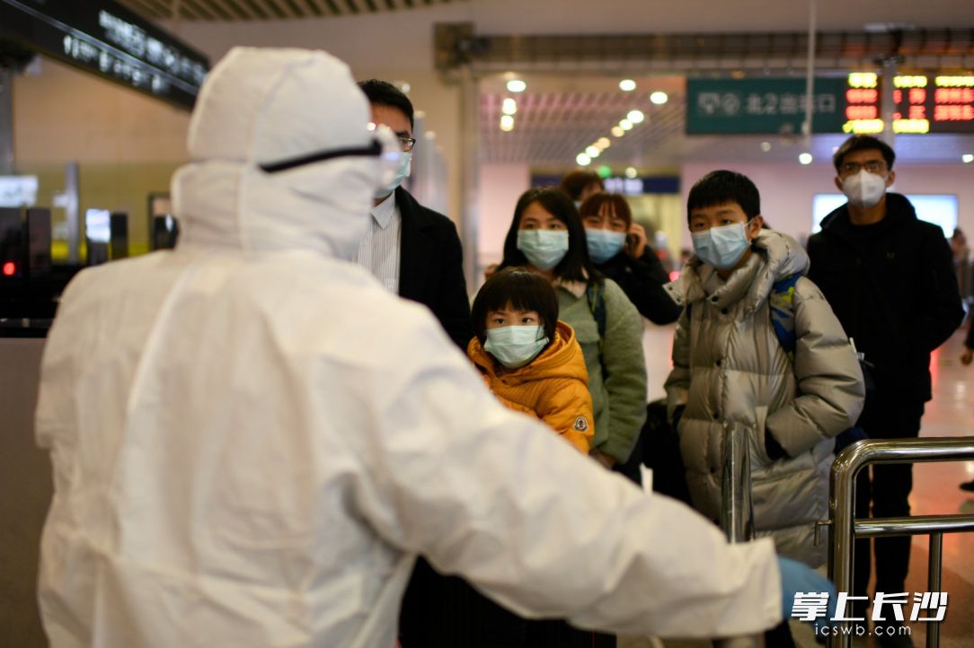 1月27日，长沙火车南站，身着防护服的工作人员对旅客进行引导。发现体温异常者，再转由在专业人员进行一步测量。长沙晚报全媒体记者 黄启晴 摄