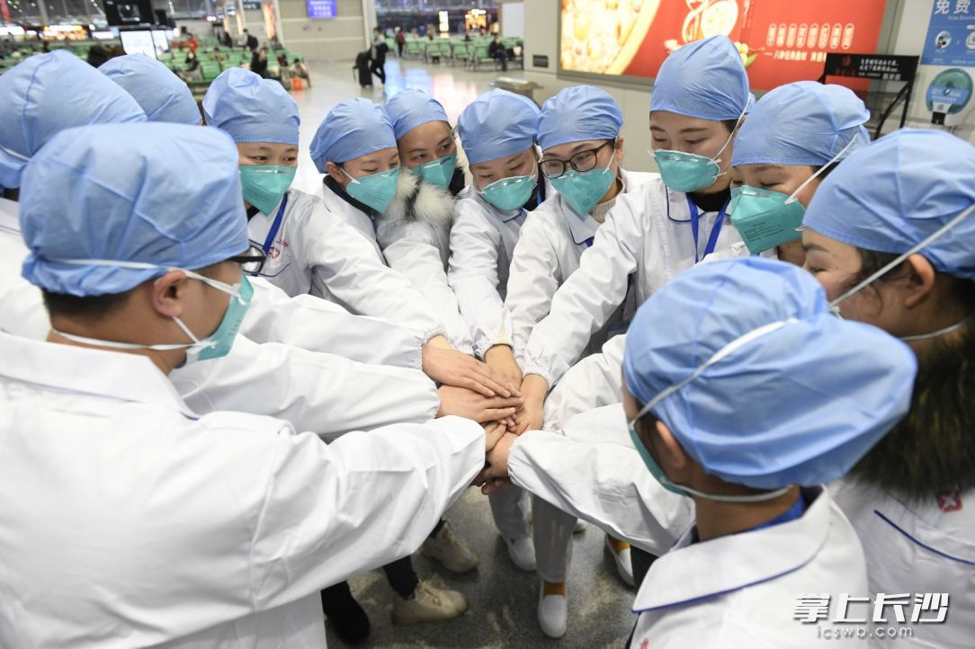 1月28日，湖南派出的赶往黄冈市的第二批援助医疗队队员结集出发前，互相加油。长沙晚报全媒体记者 黄启晴 摄