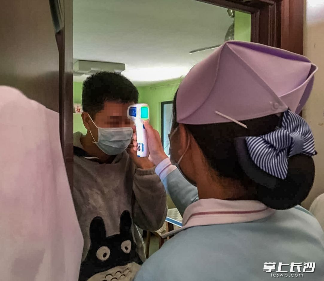 1月29日，黑石铺社区养和医院的志愿医疗队医护人员，带着酒精及口罩等物资，和社区工作人员一起，挨家上门为隔离家庭成员进行上门测试体温，并送上了防护和消毒物资。长沙晚报全媒体记者 陈飞 摄