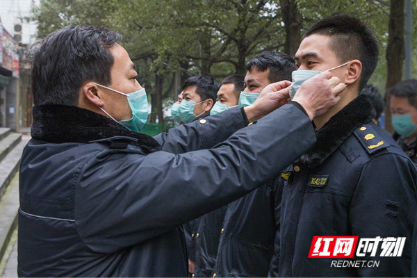 大队长为队员整理口罩。