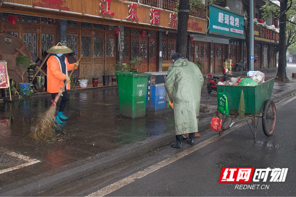 环卫工人李建华、杨爱青夫妇在沿江大道清洁卫生。