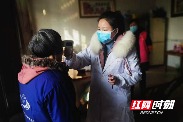 唐永义在给新农社区从湖北返乡人员检测体温.jpg