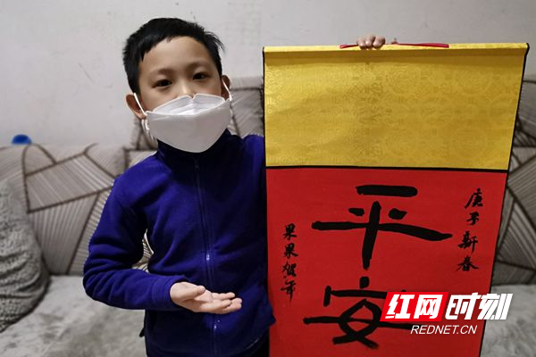 7岁的陈禹君展示“平安”书法作品.jpg