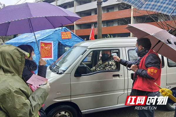 郴州市人大机关党员、北湖区下湄桥街道同辉社区瓷厂小区党员志愿者在值守点对进入小区人员检测体温登记.jpg