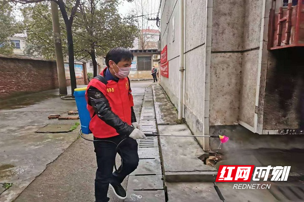 党员志愿者在无物业小区楼栋消毒.jpg