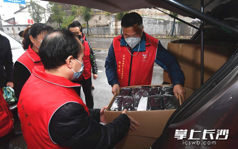 杨士泉（图右）和小蜜蜂志愿者协会志愿者一起搬运防疫物资。图片均由市文明办提供