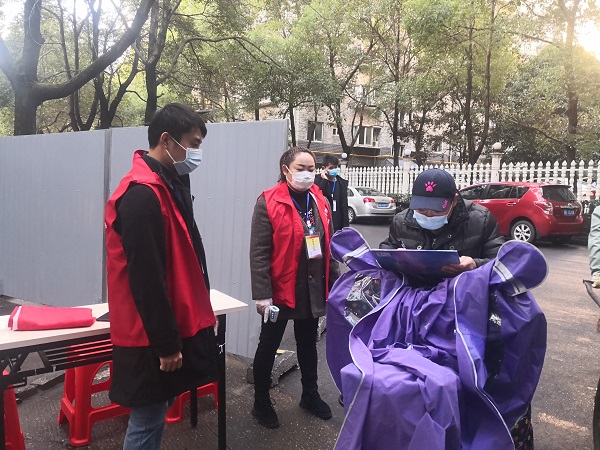 英才园小区实行封闭式管理，志愿者为入小区行人测体温后登记.jpg