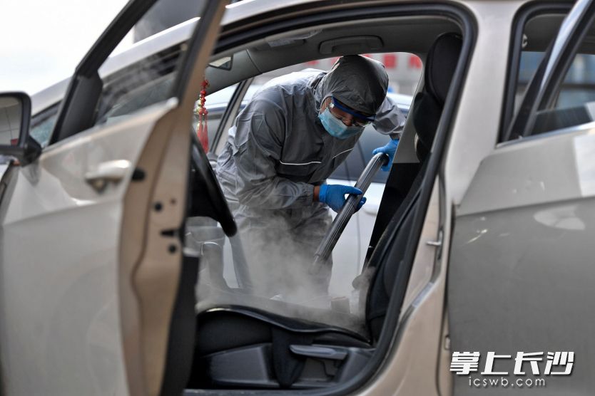 长沙城投中青路西加油站“逆行车”消毒点，工作人员使用雾化机、蒸汽清洗机等免费为车辆消毒。