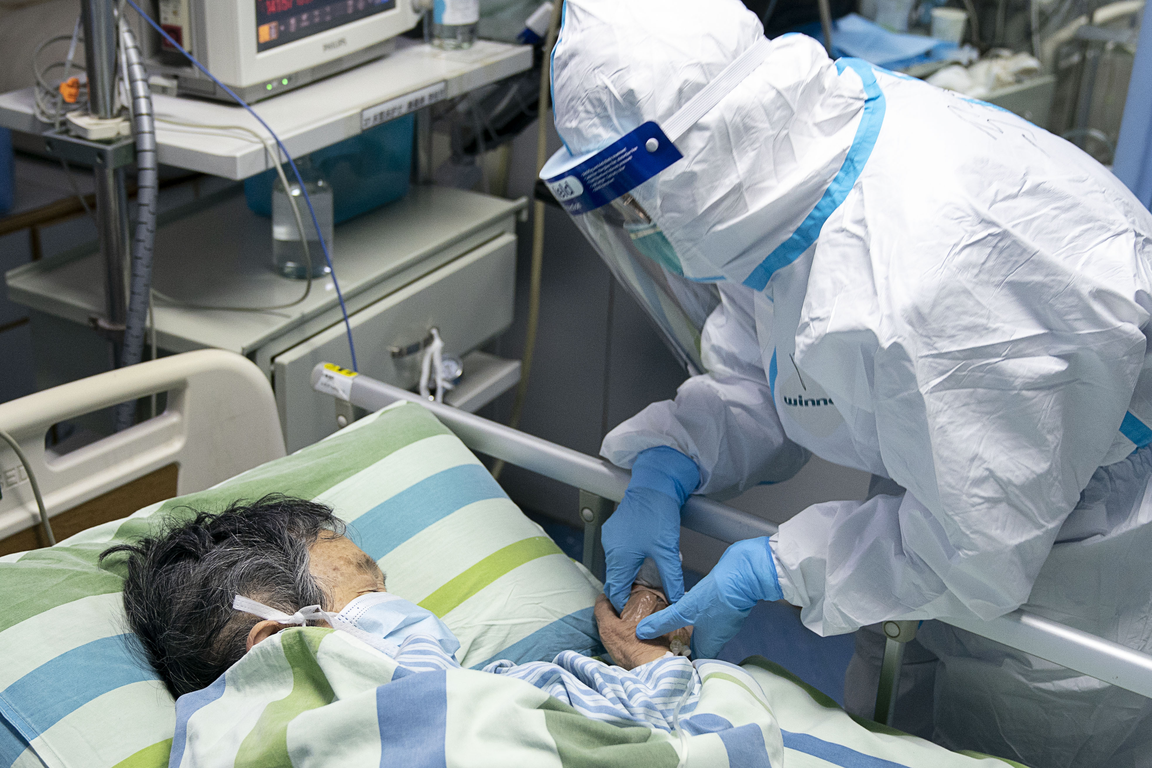 02 1月24日,在武汉大学中南医院重症隔离病房,护士长马晶握住病人的手