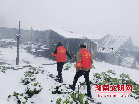 2月15日，武陵源区风雪交加，天子山街道疫情防控志愿者走乡串户为村民量体温。 刘芙蓉 摄.marked.jpg