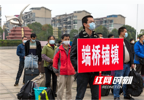 各乡镇组织的外出务工的贫困户正在等待上车。（唐明登）