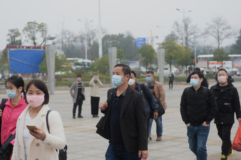 2月26日,务工人员在新化县体育中心前集合,准备乘车.