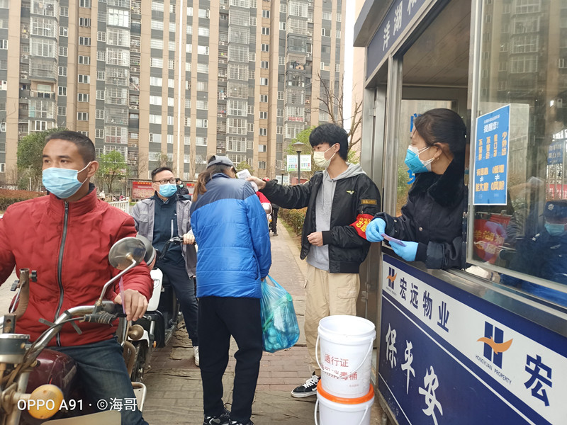小莫正在为进出居民量体温.jpg