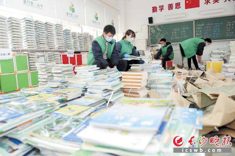 　　新竹二小老师根据年级、班级、小区等对新教材分门别类，进行分拣和打包装袋，确保精准派送。长沙晚报全媒体记者 石祯专 摄
