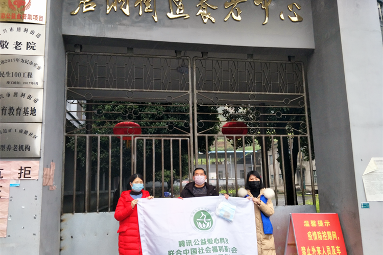 工作人员将口罩送到唐洞街道养老中心