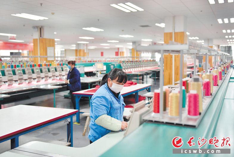 　　梦洁家纺生产车间，工人戴着口罩正在有序工作。邹麟 摄